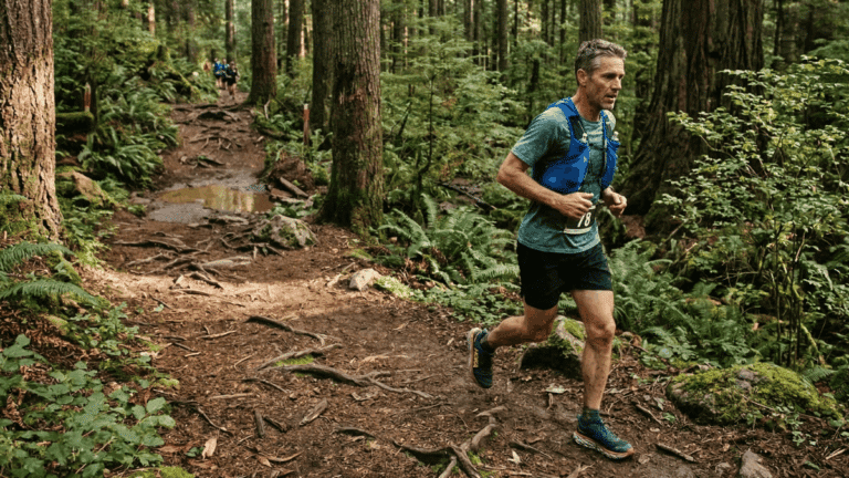 An ultramarathon runner on a trail in the forest.